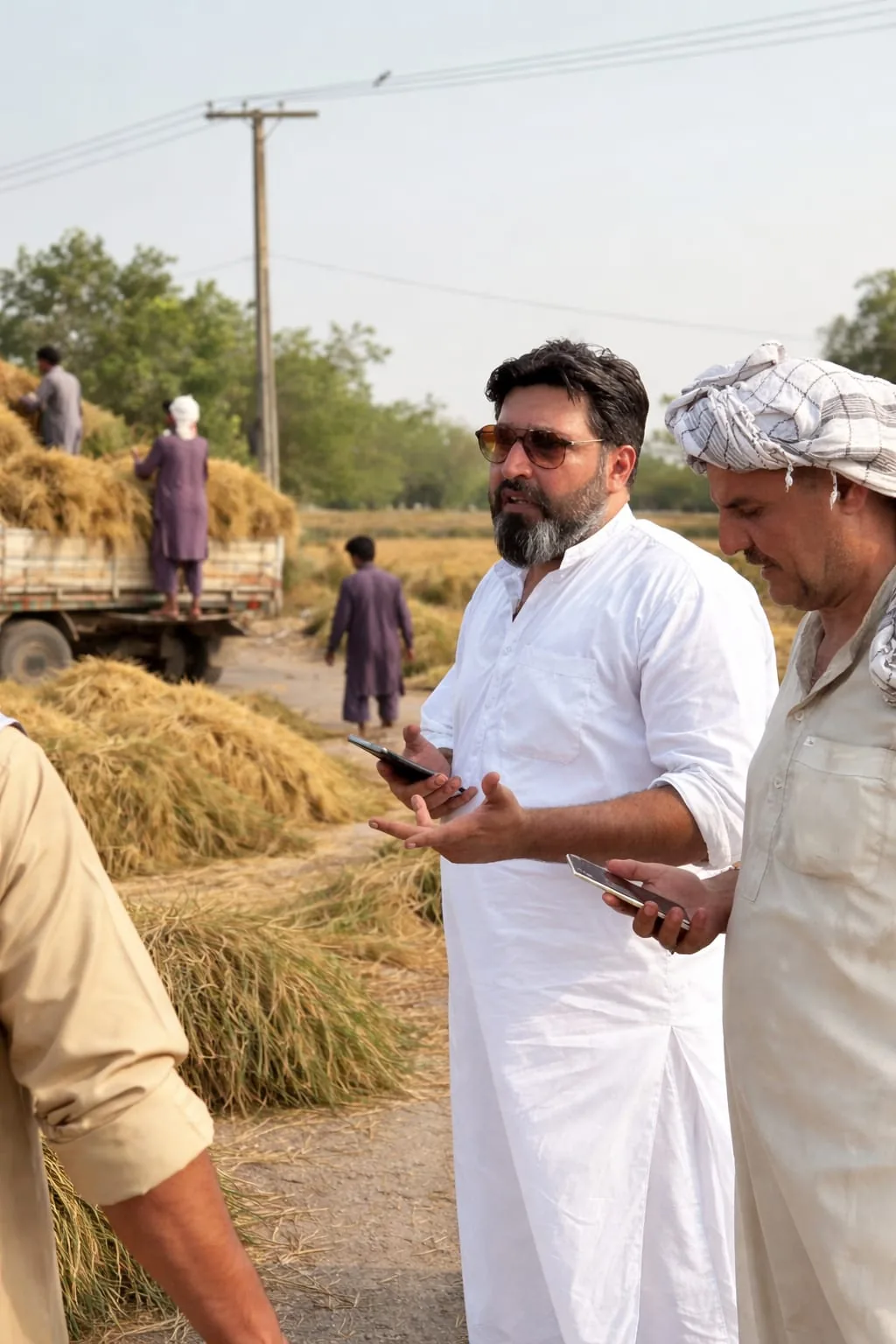 Ahsan speaking with a farmer beside the crop